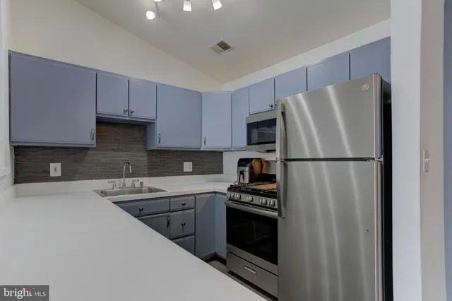 a kitchen with a refrigerator sink and stove