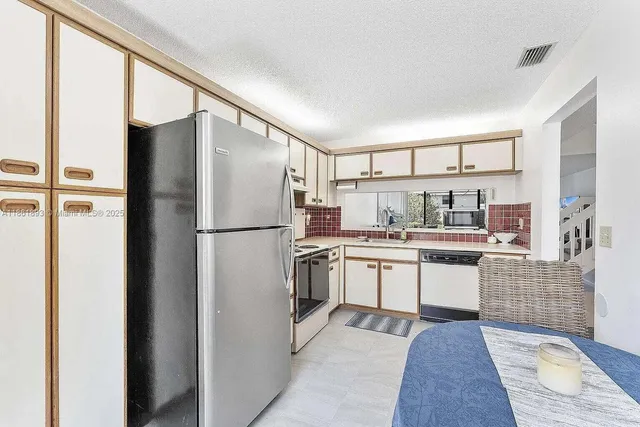 a kitchen with stainless steel appliances granite countertop a refrigerator a sink and a stove