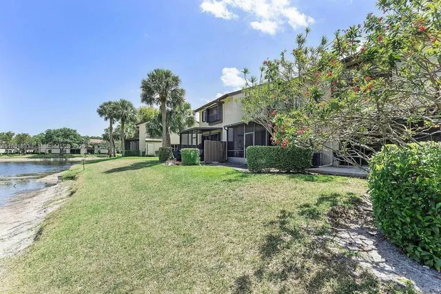 a view of a house with a yard and a fountain
