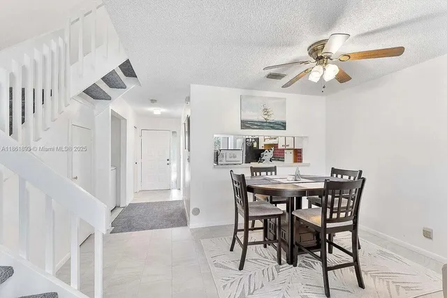 a view of a dining room with furniture and a chandelier fan