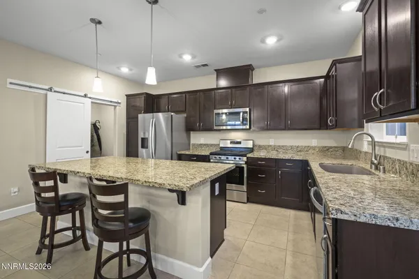 a kitchen with stainless steel appliances granite countertop a sink refrigerator and cabinets