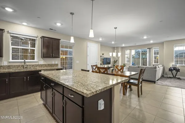 a kitchen with a stove a sink a counter top space and living room view
