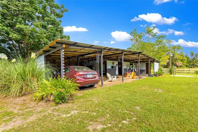 a view of a big yard with table and chairs and potted plants