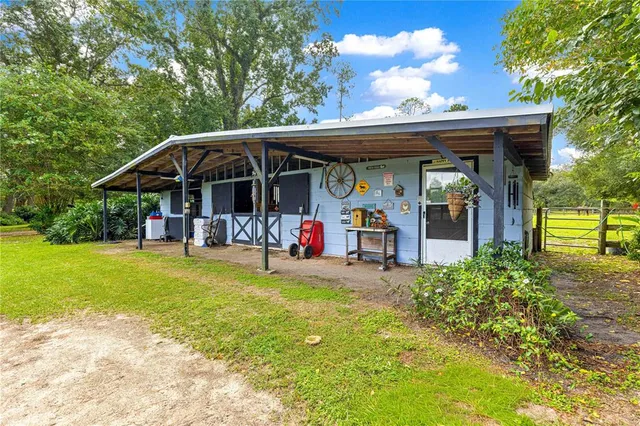 a view of a patio with a table and chairs under an umbrella with a small yard