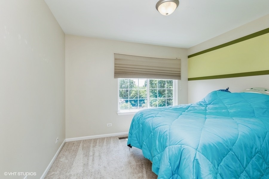 9675 Newton Road Huntley, IL 60142 - Photo 12 of 18 a bed sitting in a bedroom next to a window