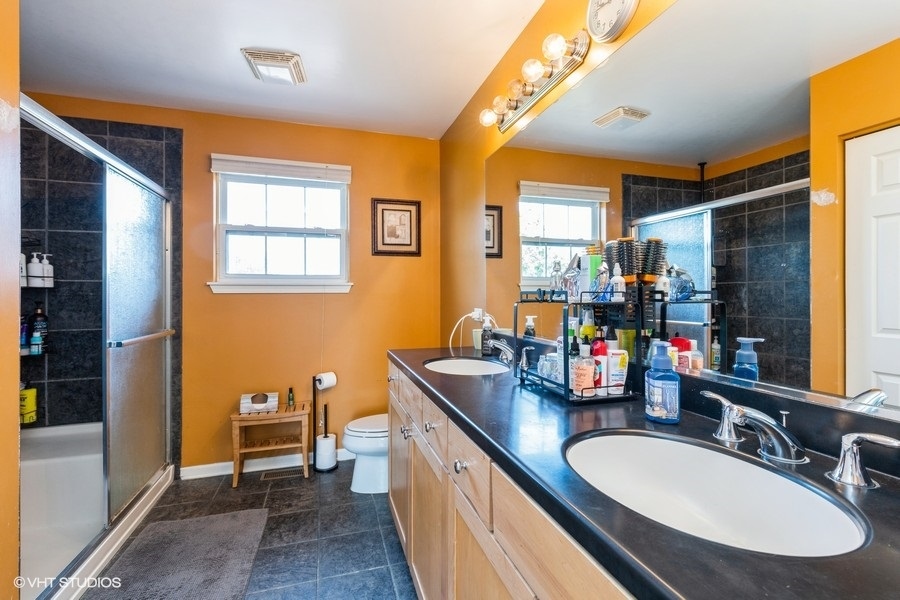 9675 Newton Road Huntley, IL 60142 - Photo 14 of 18 a bathroom with sink a mirror a bathtub and next to a window