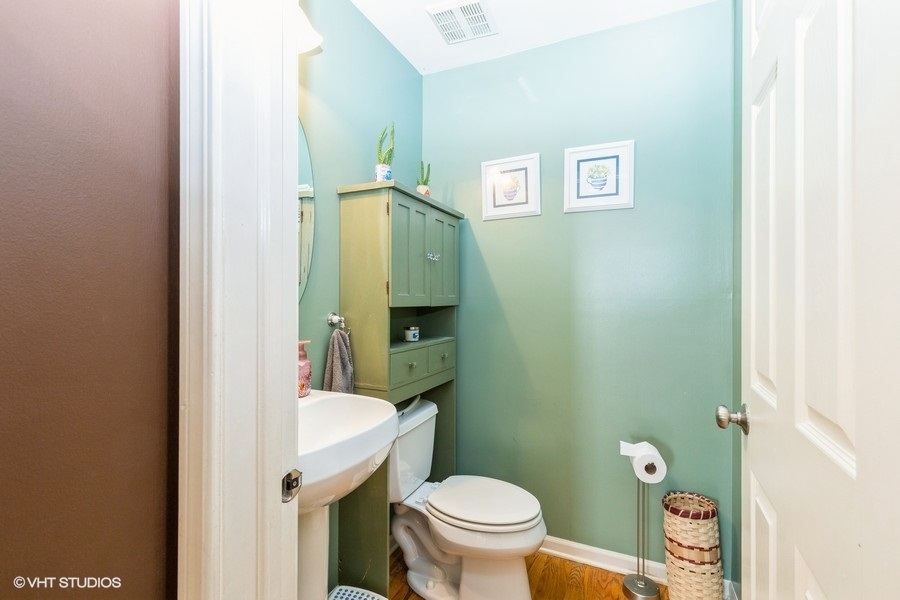 9675 Newton Road Huntley, IL 60142 - Photo 8 of 18 a bathroom with a toilet a sink and mirror