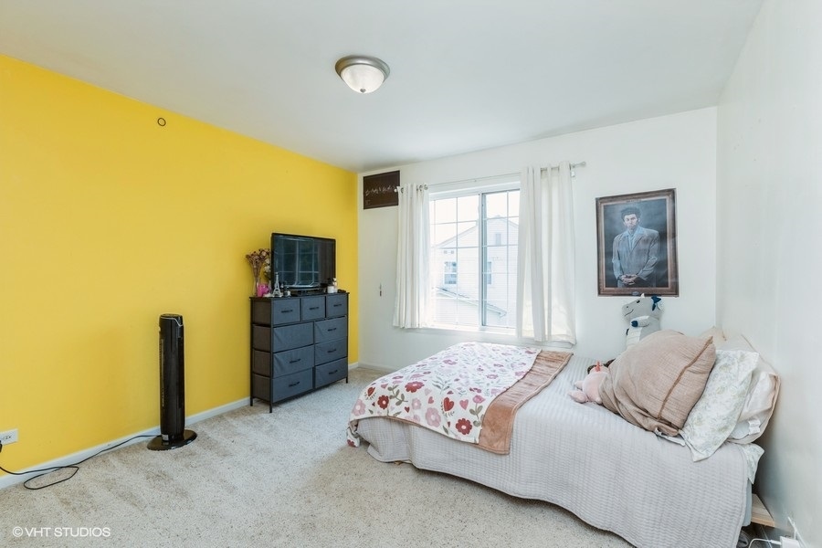 9675 Newton Road Huntley, IL 60142 - Photo 10 of 18 a bedroom with a bed and a flat screen tv