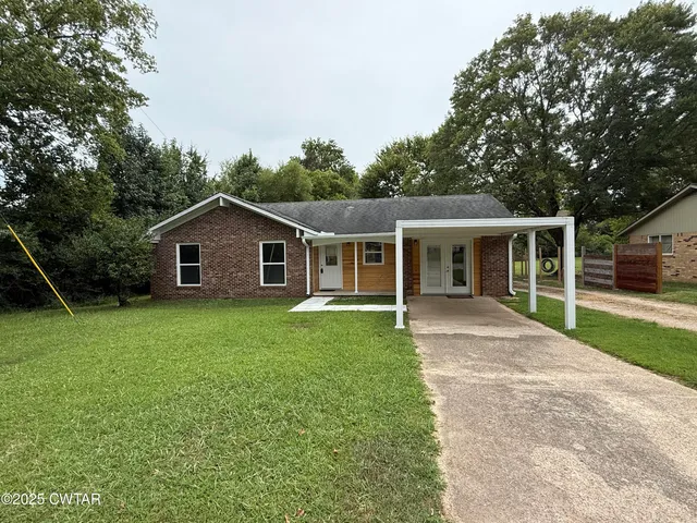 a front view of house with backyard and green space
