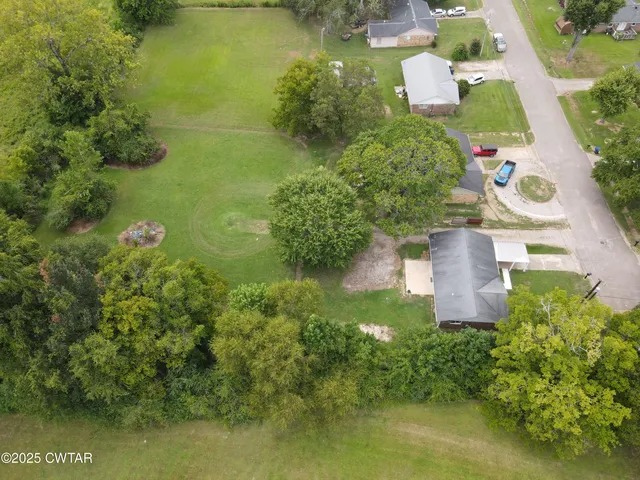 an aerial view of a house with a yard and lake view