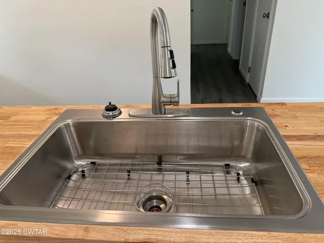 a living room with hard wood floors and a kitchen