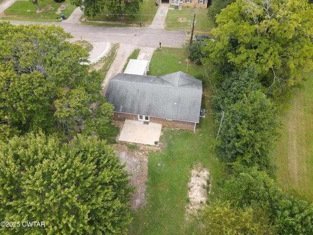 an aerial view of a house with swimming pool and garden