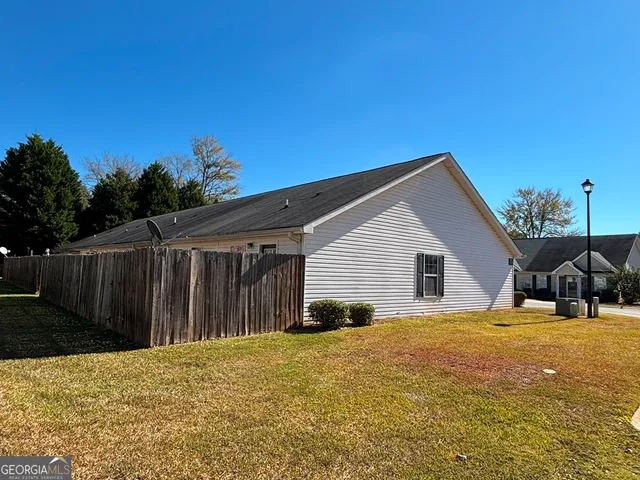 a view of a house with backyard and sitting area