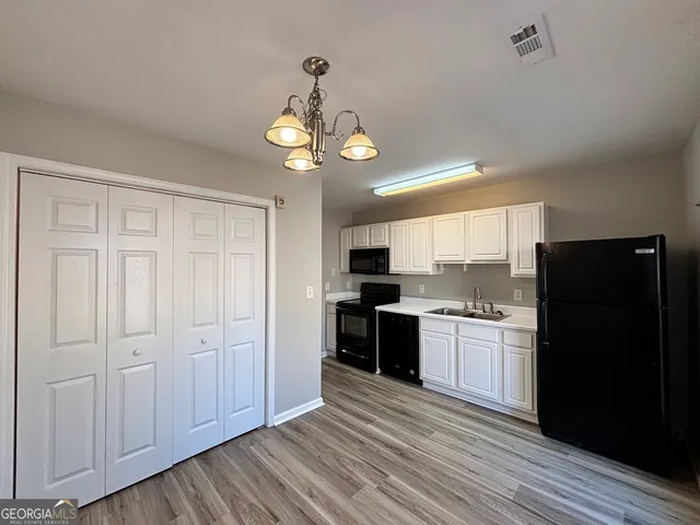 a kitchen with a refrigerator a stove top oven a sink and dishwasher