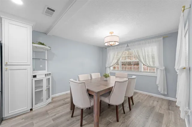 a kitchen with refrigerator and chairs