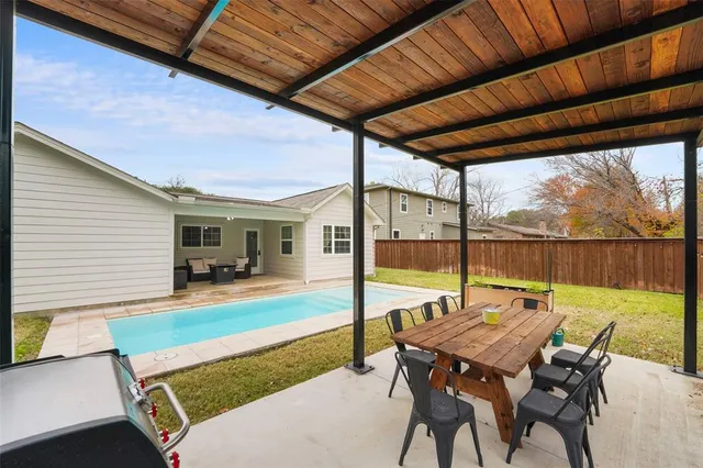a view of a patio with a dining table and chairs with wooden floor