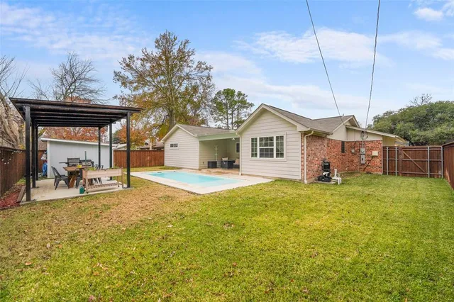 a view of a house with backyard and sitting area