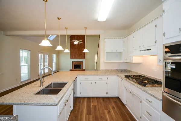 a kitchen with granite countertop a sink stove and cabinets