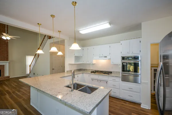 a kitchen with stainless steel appliances granite countertop a sink a stove and a refrigerator