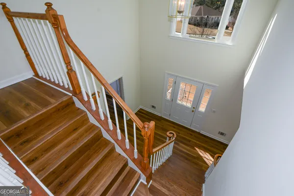 a view of an empty room with wooden floor and windows