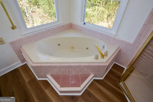 an empty room with wooden floor and a ceiling fan