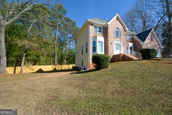 a view of a white house with a yard and plants
