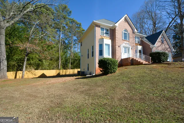 a view of a white house with a yard and plants