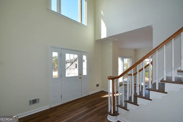 a view of entryway and hall with wooden floor