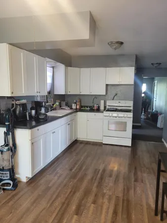 a view of a room with wooden floor and furniture