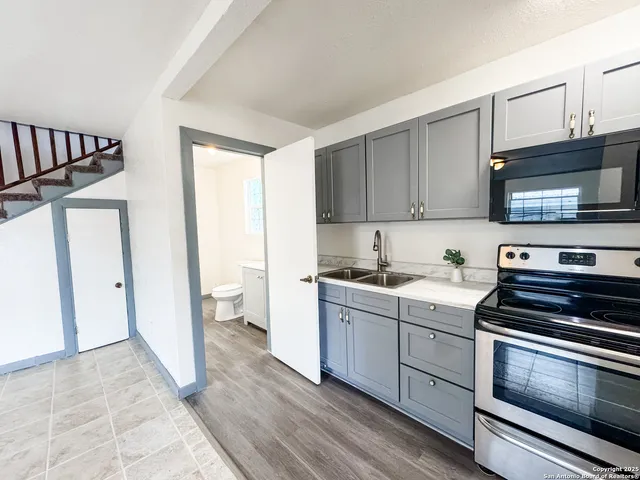 a kitchen with stainless steel appliances a stove a sink and a microwave