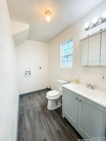 a bathroom with a toilet sink a mirror and vanity