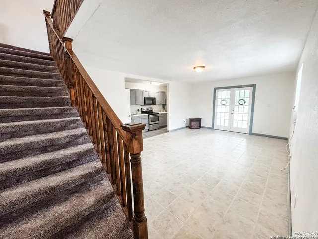 a view of a livingroom with stairs and a ceiling fan