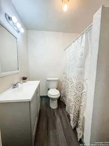 a bathroom with a toilet a sink and a mirror