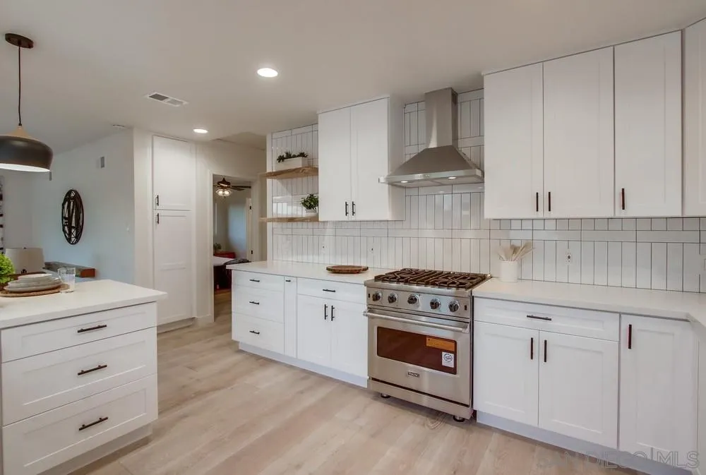 809 Colima Street La Jolla, CA 92037 - Photo 6 of 25 a kitchen with stainless steel appliances granite countertop a stove a sink and a refrigerator
