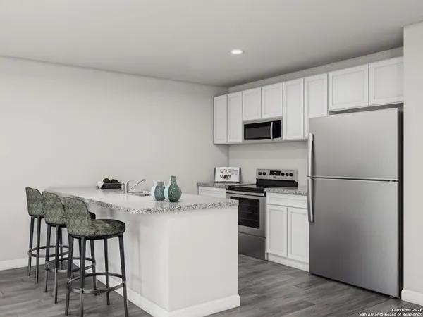 a kitchen with stainless steel appliances a refrigerator stove microwave and white cabinets