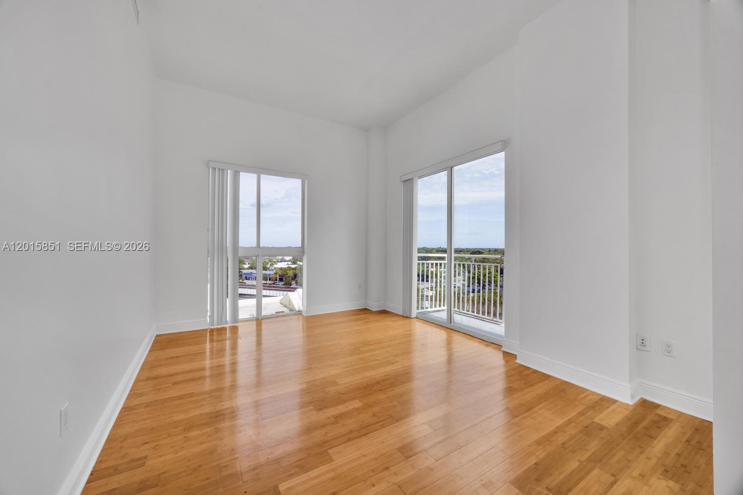 7275 Southwest 90th Street, Unit C719 Miami, FL 33156 - Photo 8 of 25 a view of an empty room with window and wooden floor