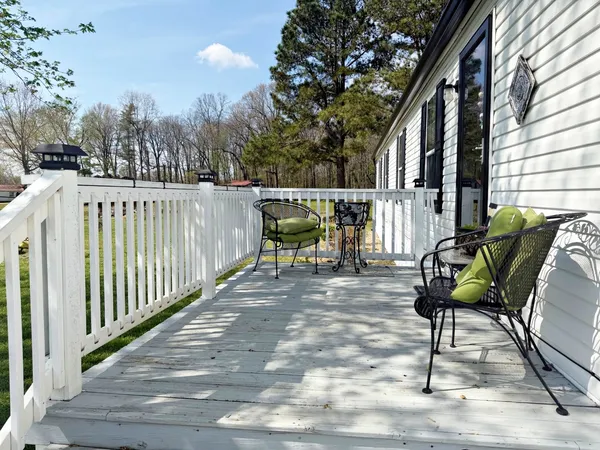 a view of a deck with furniture and a floor to ceiling window