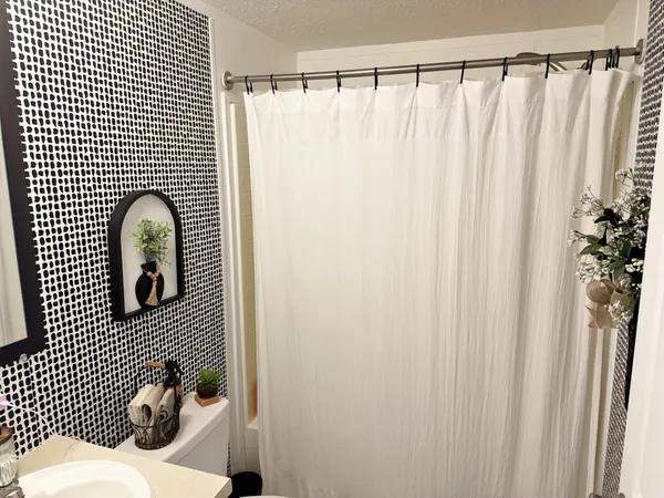 a bathroom with a shower curtain and a window