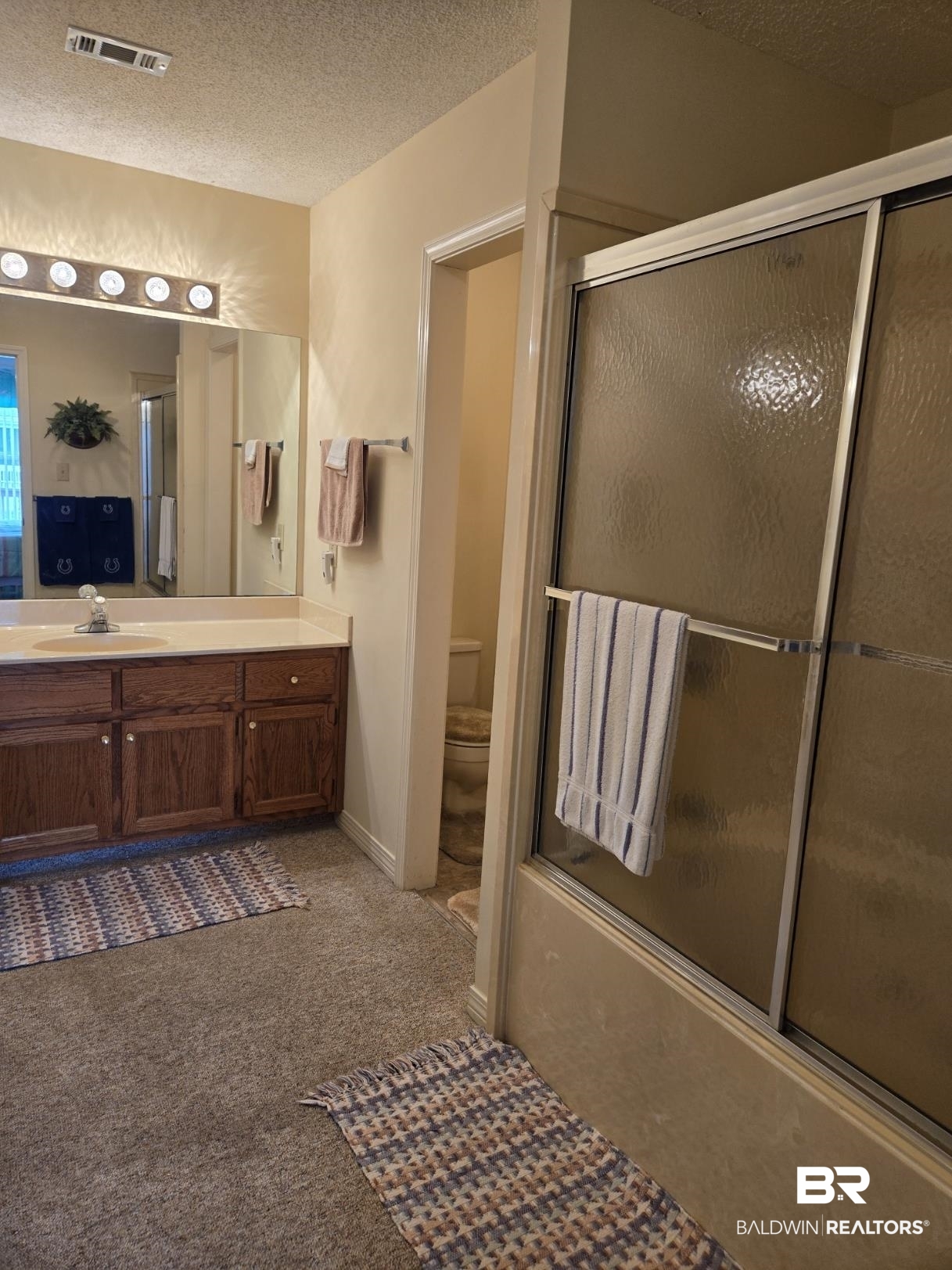 3200 Loop Road, Unit 87 Orange Beach, AL 36561 - Photo 29 of 46 Full bathroom with vanity, a textured ceiling, shower / bath combination with glass door, and toilet