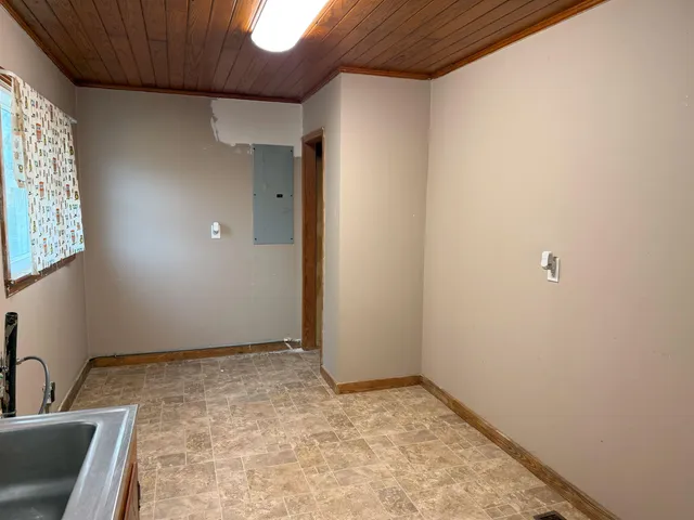 an empty room with windows and cabinet
