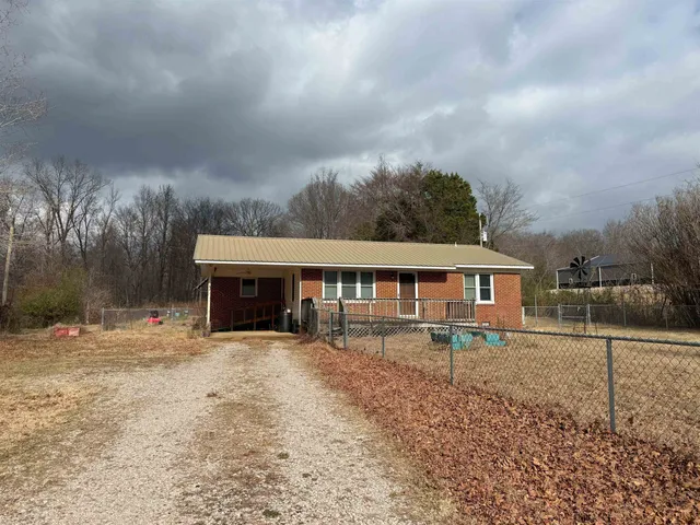 a view of a house with a yard and fence