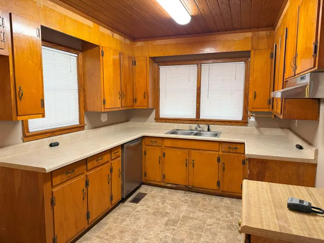 a kitchen with stainless steel appliances granite countertop a sink and a wooden cabinets