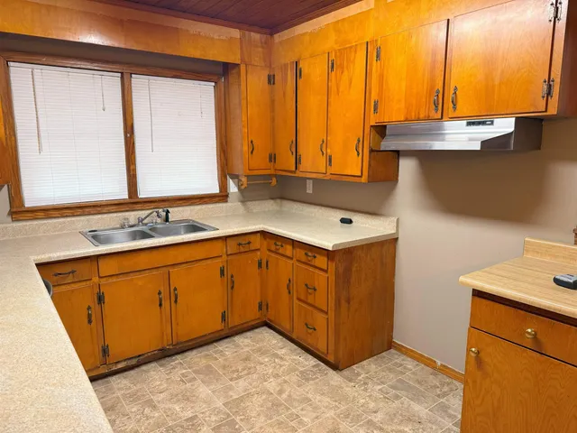 a utility room with a sink a mirror and a window