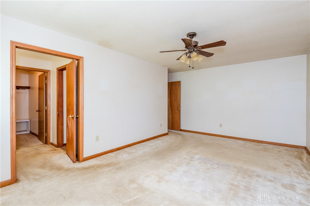 5709 Preble County Line Road Lewisburg, OH 45338 - Photo 20 of 47 This spacious bedroom offers an open layout, plush carpeting, and warm wood trim.