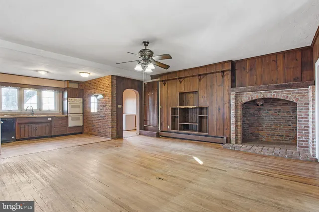 a view of an empty room with a fireplace and a window