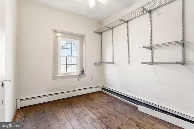 a view of a room with wooden floor and white walls