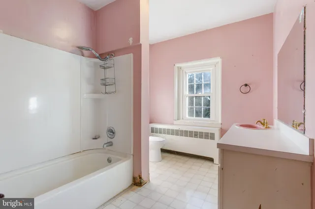 a bathroom with a tub sink and mirror