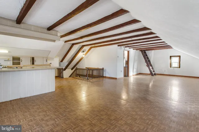 a view of empty room with wooden floor and windows