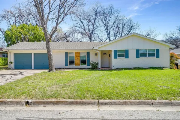 a view of a house with a yard and large tree