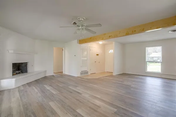 wooden floor fireplace and windows in an empty room